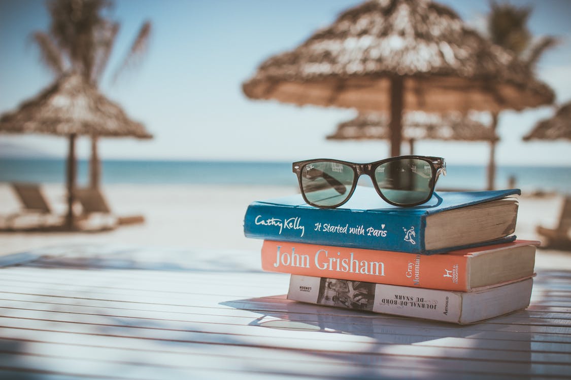 a Photo of Books and Glasses at the beach